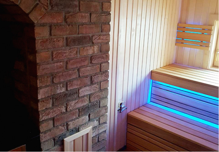 Sauna avec poêle à accumulation de chaleur et fenêtre