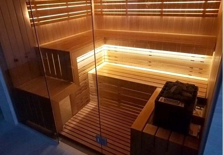 Sauna avec façade vitrée et vue sur la piscine