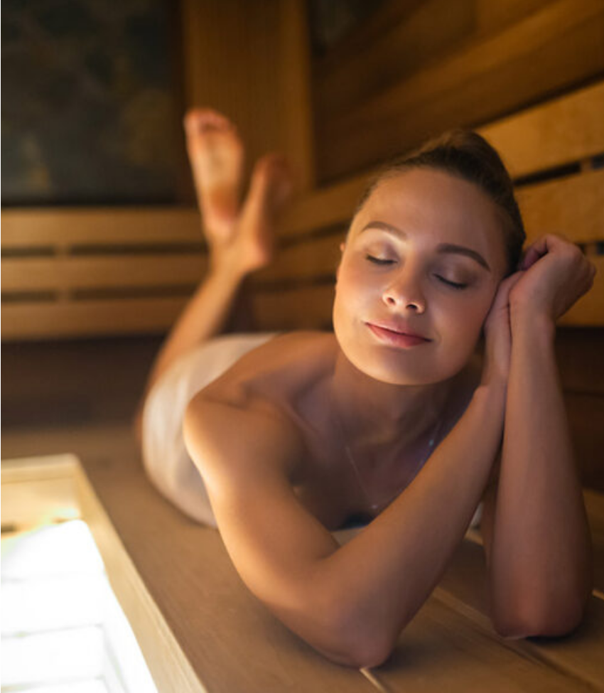 Une femme se repose allongée sur un banc de sauna