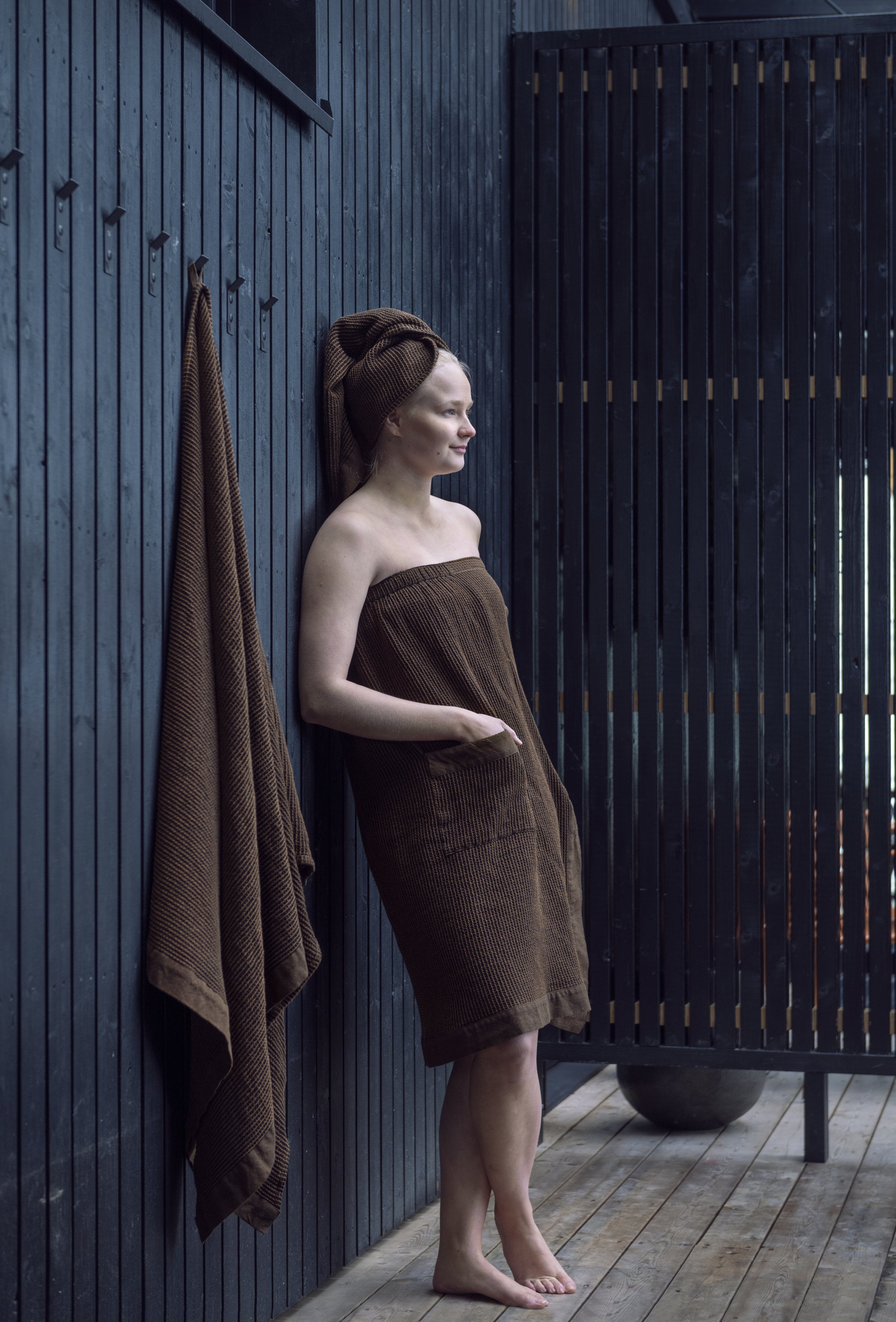Femme portant un tablier de sauna et une serviette pour les cheveux