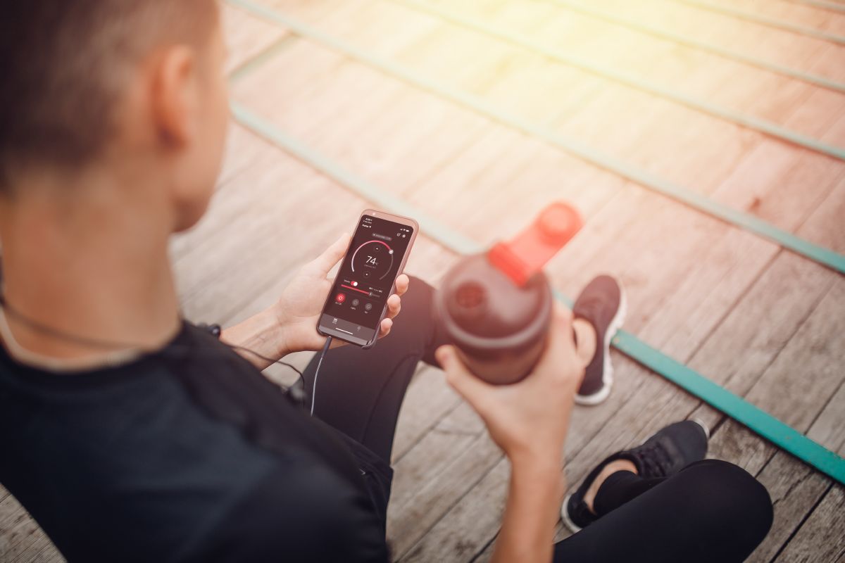 un athlète tenant une bouteille d'eau et un téléphone