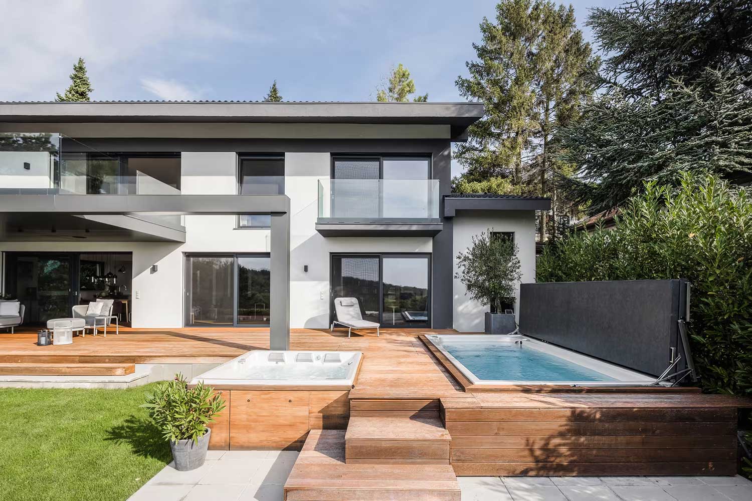 Piscines spa et spa de nage USSPA avec couvertures surélevées installées à côté de la terrasse d'une maison moderne