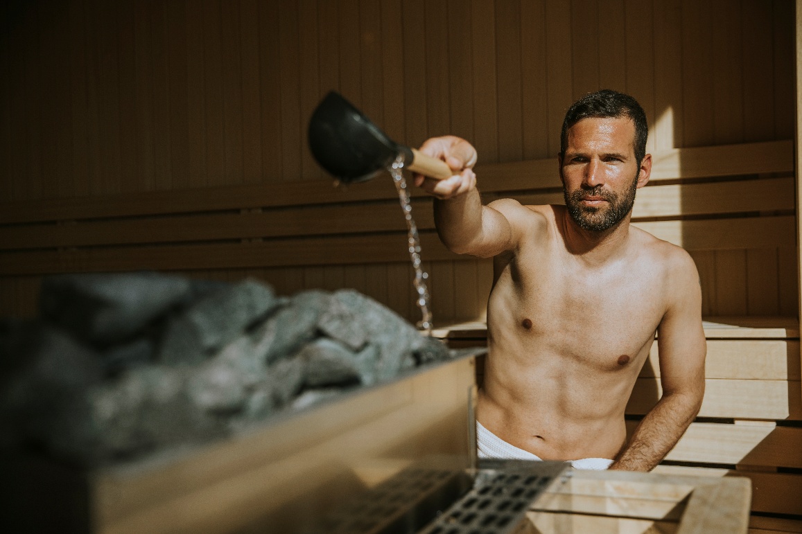 Verser de l'eau sur les pierres du sauna
