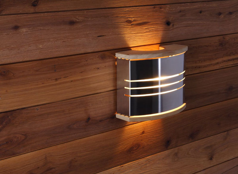 Lampe de sauna murale en métal et bois sur le mur du sauna.