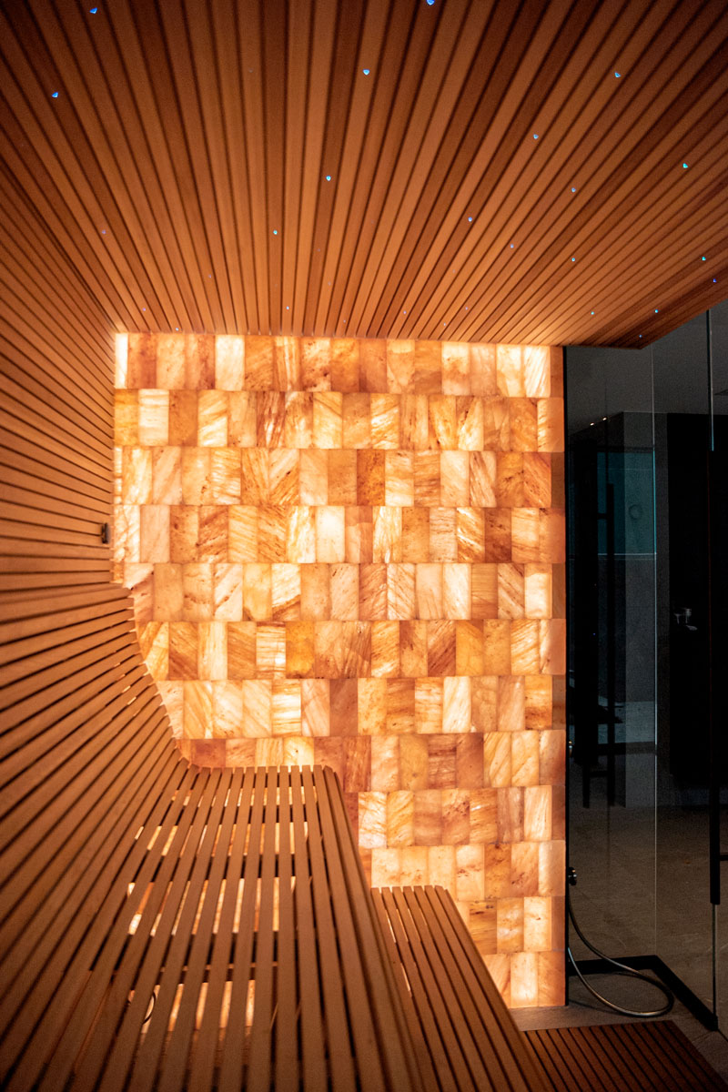 Mur de briques de sel de l'Himalaya illuminé et plafond de sauna étoilé.