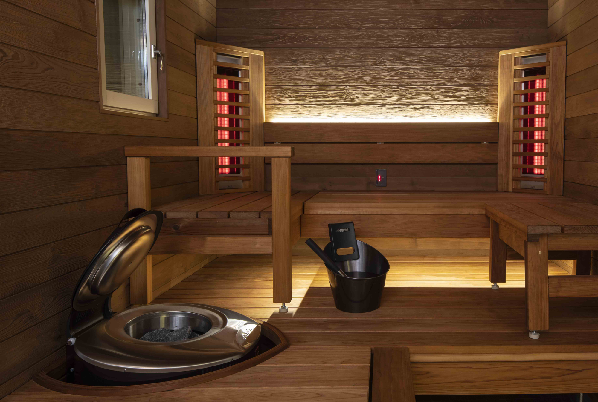 Intérieur de sauna infrarouge avec bancs en bois, éléments chauffants et poêle pour la détente et le bien-être